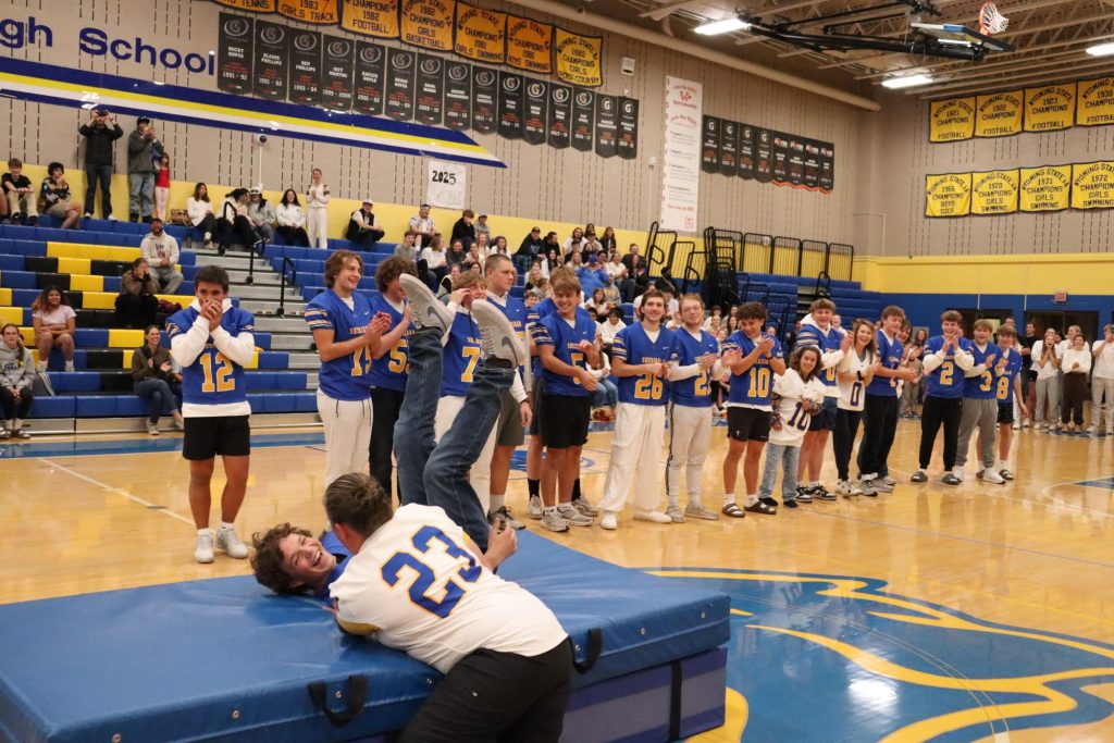 Senior Austin Orum gets tackled by his mother at the homecoming pep assembly. (Zane Doyle)